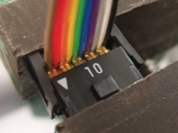 38 Attach a 10-pin female connector to one end of the cable. Insert the end of the flat cable so that the triangle mark indicated by the dotted circle in photo 10.