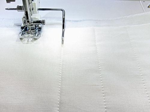 8. Continue to stitch additional lines, using the quilting bar to create evenly spaced rows (1½" apart) of quilting on both sides of the center line. 9.