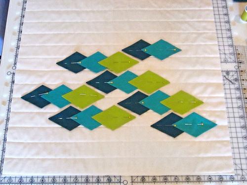 Your horizontal quilting lines act as a grid to align all the pieces. Pin in place. 2. Repeat to place the completed arrangement of diamond units onto the second quilted square. 3.