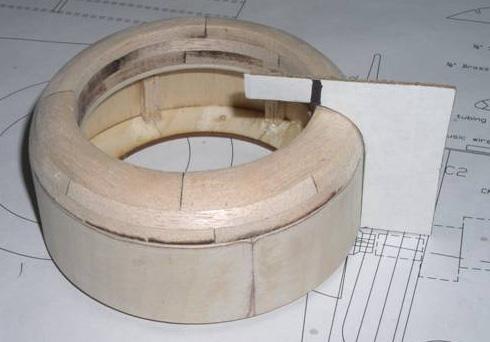 When the glue has set, bend one of the ply pieces around the ring, centering the end on the middle of the spreader bar. Mark where the other end of the ply falls on the circumference of the ring.