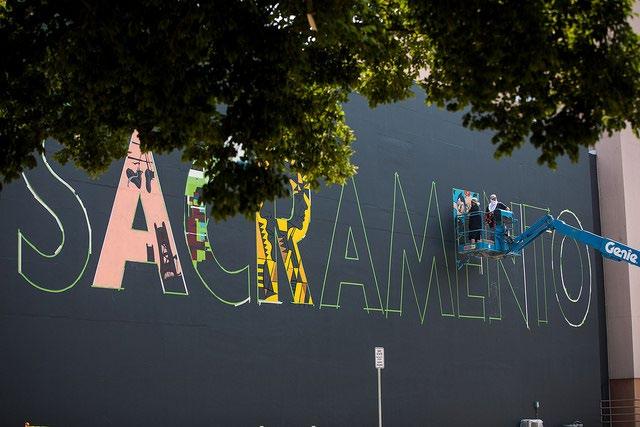 Artists painting the SACRAMENTO mural on the Sac State Theater building. This is one of many murals painted around the city August 9-19.