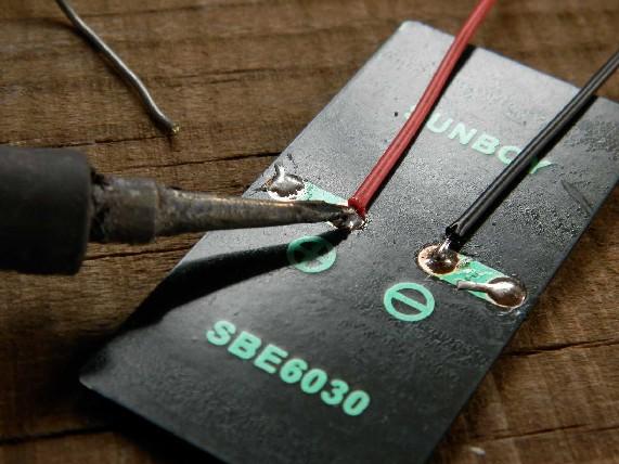 * (If we have red/black wires.. Else another colour does it as well.) Solder the wires to the pads PV+ and PV- of the board.