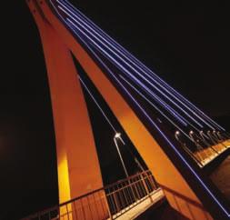 The ultra bright, full color installation handsomely illuminates the 12 steel bands spanning from the top of the bridges