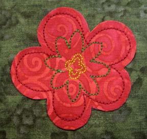 With the paper still stuck to the right side of the appliqué fabric, spray the wrong side of the fabric with temporary