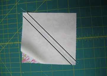 Cut along the drawn line and press the seam allowance towards the floral print side of the half square triangle.