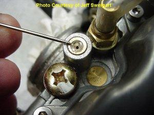 This shows a view of the right side of the carbs with the covers on. The clamp for the choke slide has already been removed and the choke cable is hanging free.