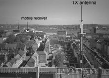On the first floor the windows were facing opposite the transmitter. Figure 2 Picture of the transmitting BS antenna (the antenna is vertically mounted) and the view of the used urban area.