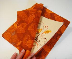 For the back fabric, cut two pieces of the print fabric to 8" wide by 10" high. Lay one of the pieces flat with the right side facing up.