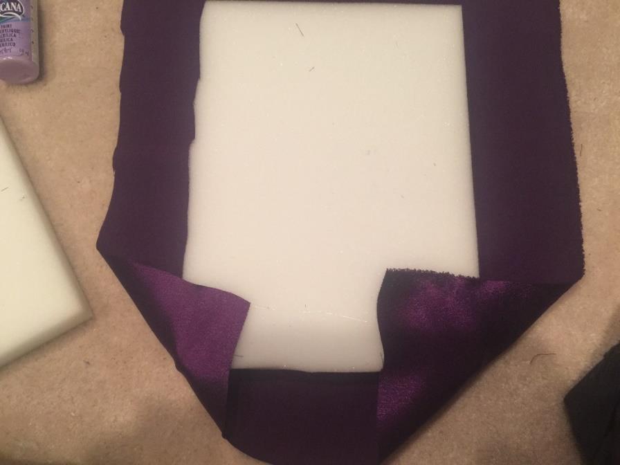 Lay the fourth piece of foam on top of the fabric and carefully cut out the size of the foam plus seven inches extra on the top and the bottom.