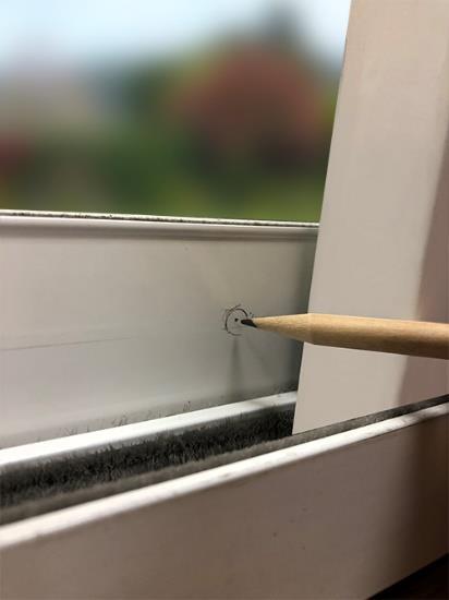 Using a pencil, trace around the circumference of the bolt on the stationary sliding glass door frame.