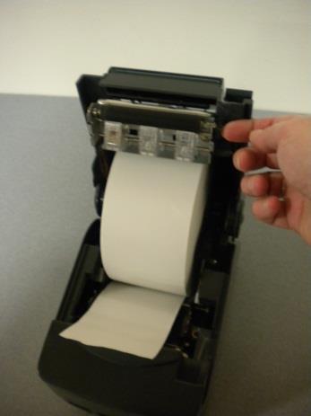 Place a new roll into the paper housing area, making sure the leading edge of the paper feeds