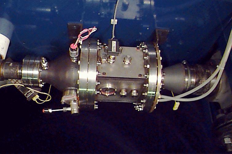 The combustor test section is mounted on a portable cart, and can be easily inserted into or removed from the facility. Figures 5 and 6 show pictures of the facility and the combustor assembly.