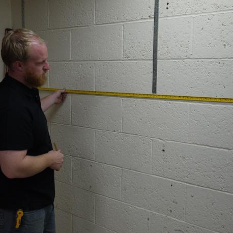 Measure out the position for the wall channels on any side walls. These wall channels will attach the wall pilasters to the side walls.