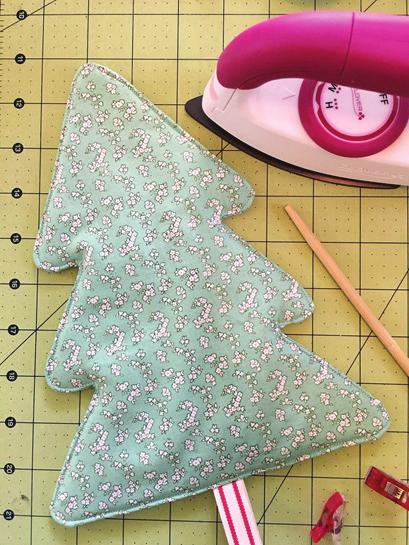 Fold 6 inches of ribbon in half, place between your two green fabrics with the edges aligned, use clips around edges to hold in place. Use sewing foot O to get that ¼ inch seam and a 2.