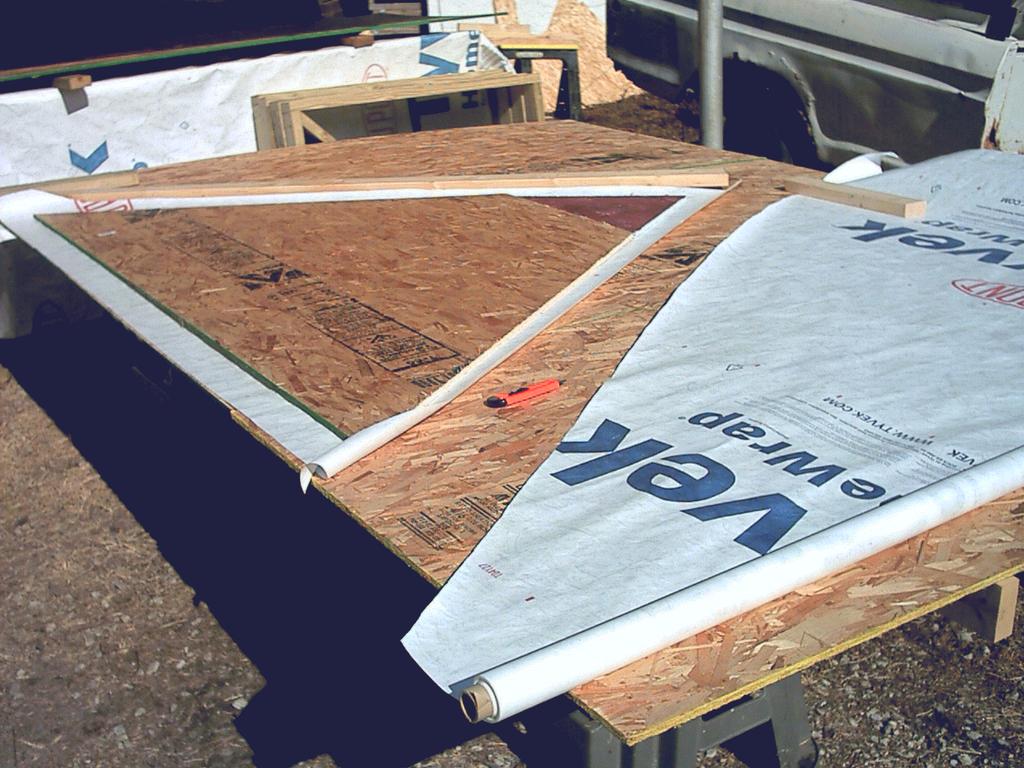 Cut the Tryvek using the sheathing as a pattern, together with a 2x4 edger as a