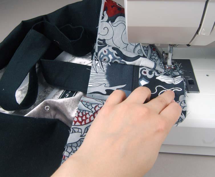 Take one of the short ends of your top section, and layer it between the bag bottom and its corresponding lining piece with right sides facing.