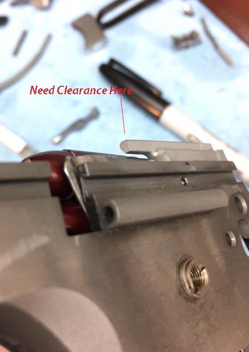 If you have contact between the ejector and the slide or the firing pin stop, remove the ejector and file down any interfering surface until the slide runs freely.