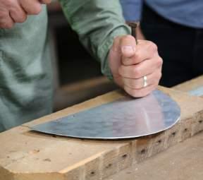 Mark and drill holes for hinges on the left and right hand side of the lid. Then drill a hole in the centre of the half circle to allow the paddle shaft be attached.