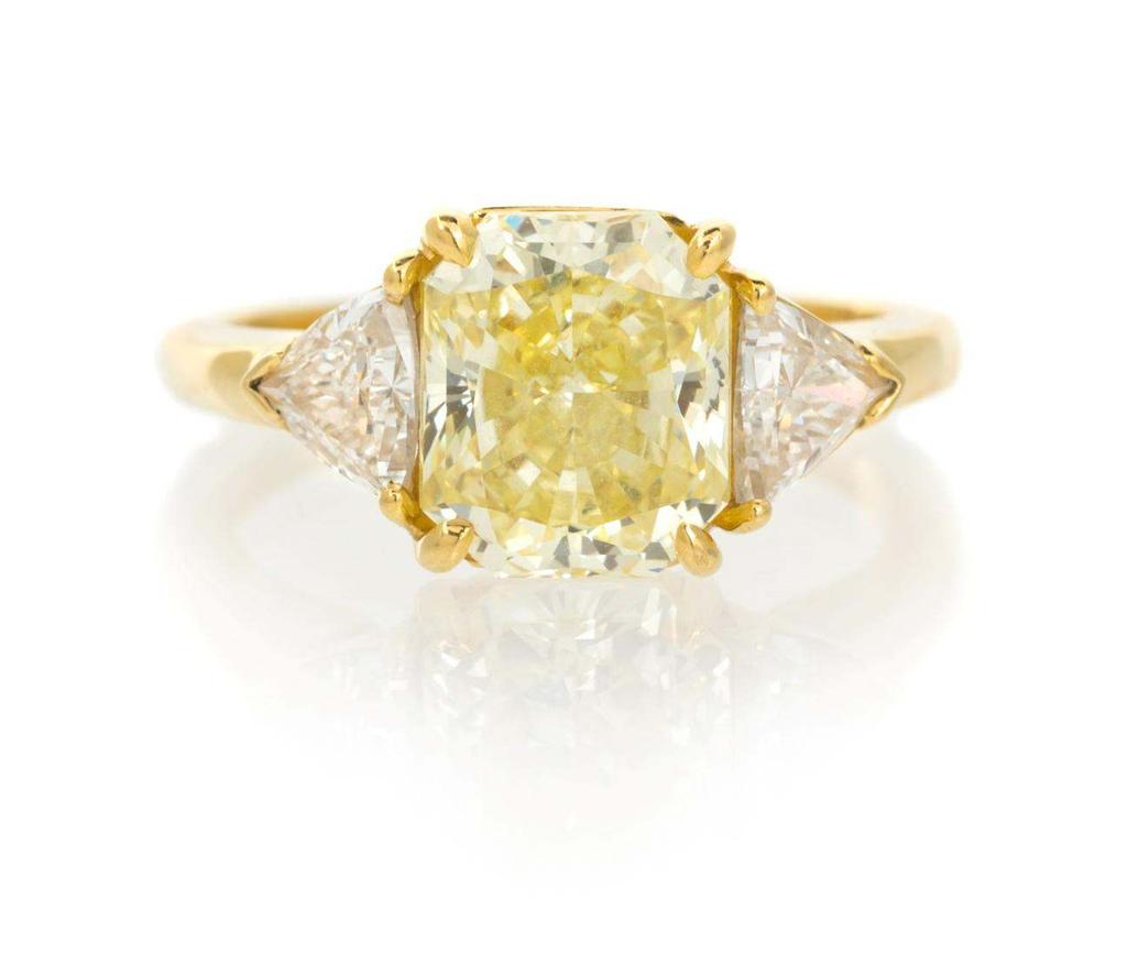 Sale 394 Lot 501 An 18 Karat Yellow Gold, Fancy Intense Yellow Diamond and Diamond Ring, Cartier, containing one radiant cut fancy intense yellow diamond weighing approximately 3.