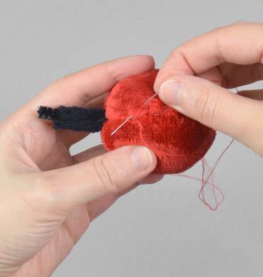 11 bring needle out close to knot pull at thread while clipping ladder stitch closed 10. stitch the pom pom closed a.