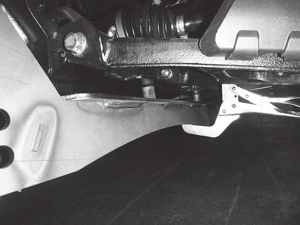 Install the driver-side bracket assembly between the frame tube and brush guard.