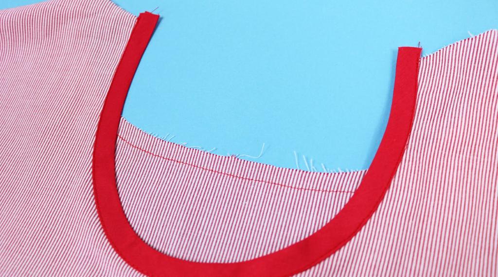 Press over 0.5cm of one long edge of the front neck bias tape.