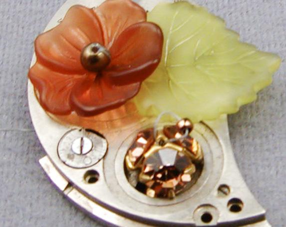 Skip the 3 mm, and sew back through the flower, the watch plate, and the Ultrasuede (photo n). Retrace the thread path several times r to secure both the flower and the leaf, and end the Fireline.