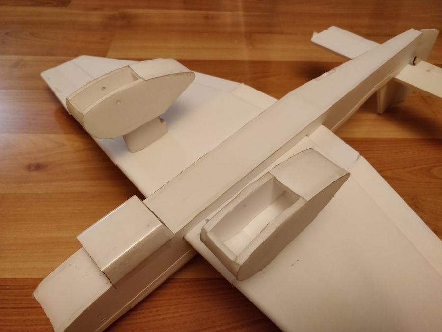 You may want to add another bead of glue to seal in the bottom flap. Start passing the wing through the airfoil cutout in the fuselage with a gentle rocking motion.