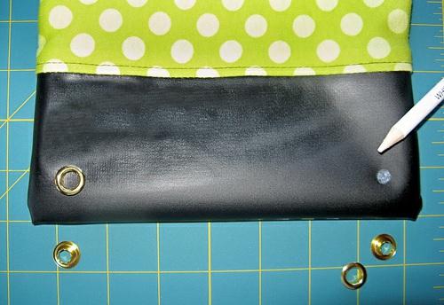 1. With a fabric pencil, mark the position of your eyelets on the bottom front of the bag.