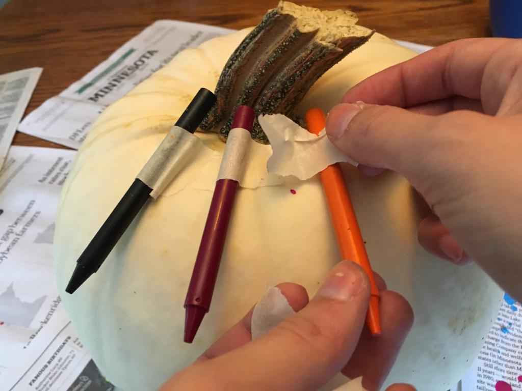 When crayons were ready, we spaced m evenly on top of pumpkin and taped m to surface.