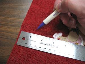 Working on the embroidered end, measure and mark the center of the top edge of the fabric by measuring and dividing by two.