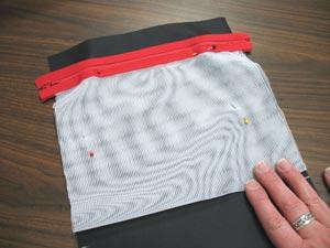Now we will add the mesh pocket to the inner lining piece. Lay the inner lining piece with the right side up and align the sides of the mesh pocket with the long sides of the lining piece.