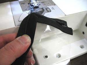 Allow the end of the zipper to extend past the edge of the vinyl about 1/4 inch. Pin in place. Sew a seam along the inner edge of the tape stopping about 1/4 inch from the first corner.