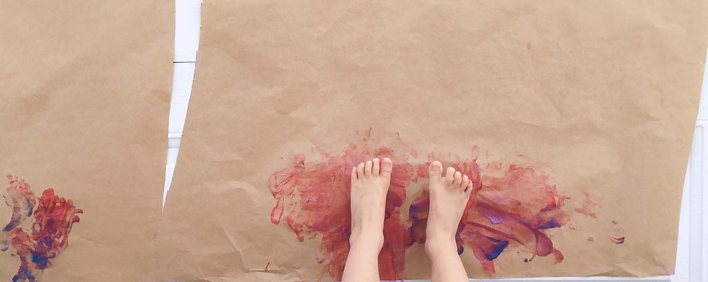 Lie down on their back with their feet positioned to touch the paper. Paint the paper with their feet!