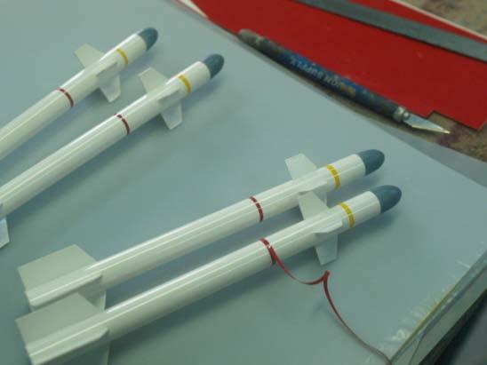 desired. Using a 1/8 piece of angle stock as a straight edge will make marking lines evenly spaced and parallel to the missile tube. The Fins are cut from the plastic strips in the kit.