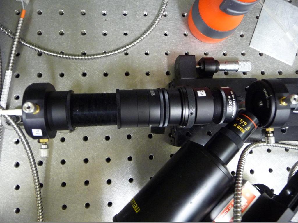 Figure 2. A photograph of the optical system we constructed using the black reimaging tubes, with the microscope used to align the focused beam with the end of the test fibre.