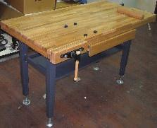 Includes both front and end vises with a double row of bench dog holes in the table for each vise.