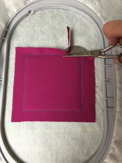 Lightly spray the back of one of the 5 squares of fabric with temporary