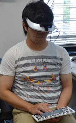 The field of view of the attached camera is much wider than the HMD, and so any objects displayed on the HMD become