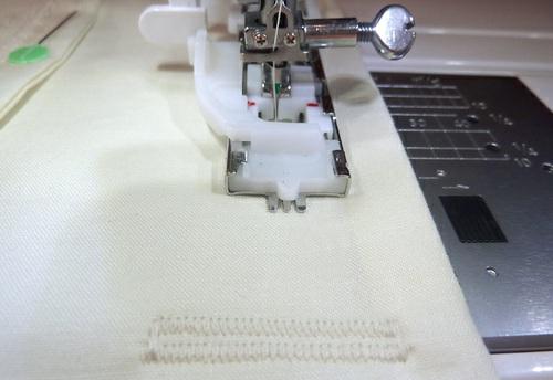 Following the instruction manual for your sewing machine, make three buttonholes: one for the center button's placement and one for each of the outside edge