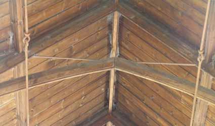 The braces form two-centred arches which are only connected to the rafters at mid level leaving the point of the arch completely free except for a steel rod which appears to pierce the top of the