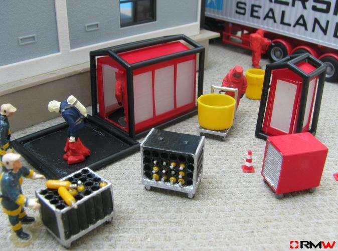 The truck, figures, building, ground cover and roll containers