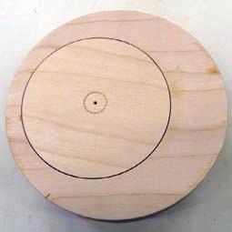 Three screws inserted through the disk and into the waste block will hold the round while using a parting tool to cut through the plywood at the 4"