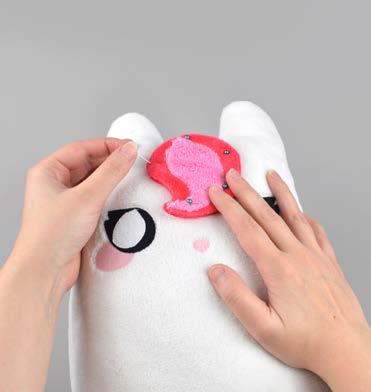 Hold it in place by putting pins down through the bangs into the body of the plush.
