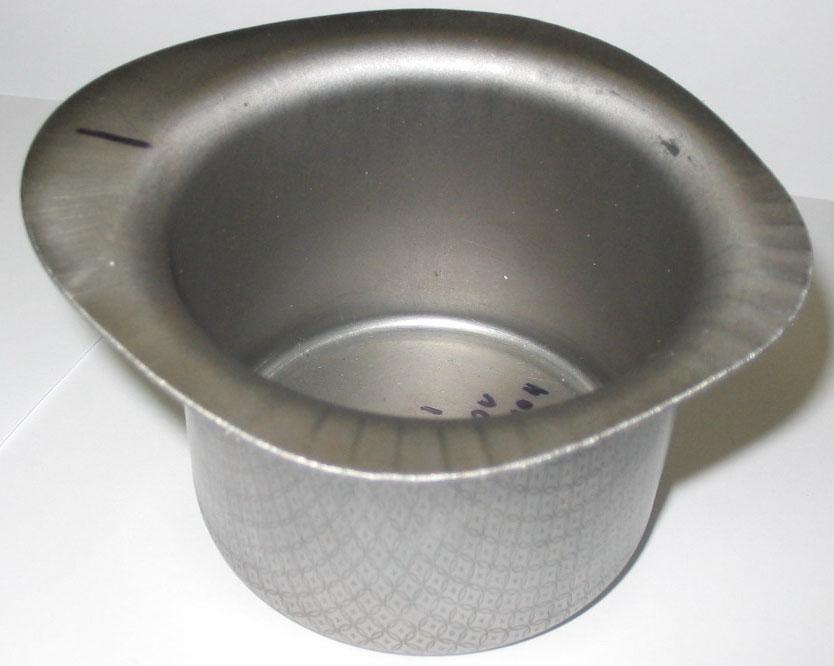 This is in the form of ears and dips located at the edges of the cup after the drawing process.