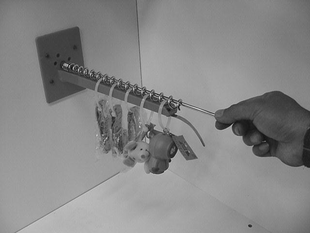 STEP FIVE: Reinsertion of Prize Locking Pin. Position the Hanging Ties on the prize arm as shown.