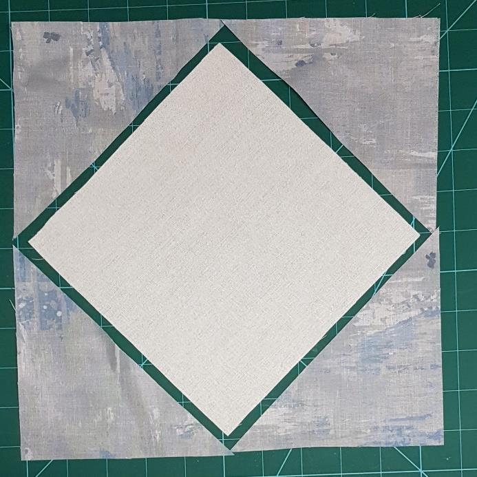 Two 10-inch squares from the Ivory Homespun fabric. 10. Cut the squares in half diagonally to make 4 large triangles. Pin to one corner of the Ohio star, making sure it is centrally placed.
