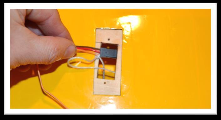 Attach the servo wire to the installation string and gently pull the wire through the wing as you insert the servo into