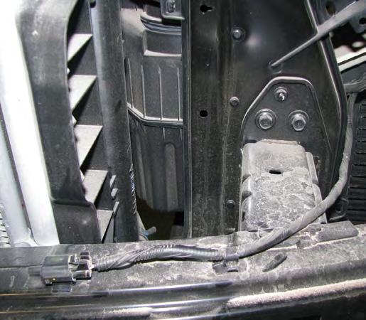 Using a 10MM socket, remove the top bolt above the bumper (white arrow on top).