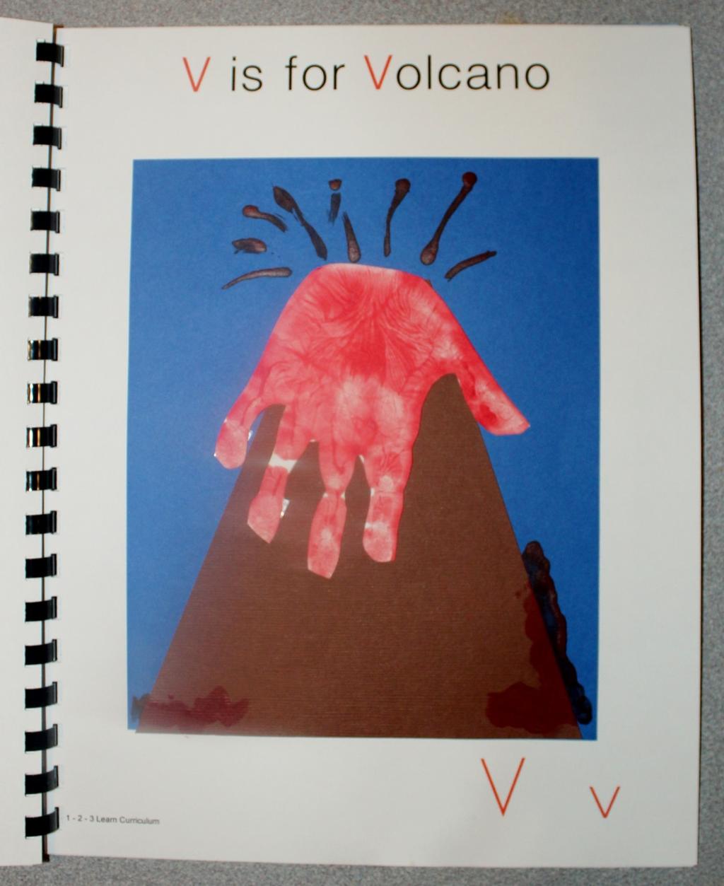 V is for Volcano Paint the child s hand red and place on white card stock. Cut out a volcano out of brown card stock and attach it to a piece of blue card stock.